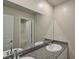 Granite countertop and dual sinks reflecting in a large mirror within a neutral-toned bathroom at 8324 S Miller Ln, Las Vegas, NV 89113