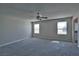 Spacious bedroom with carpet, ceiling fan, and natural light from two windows at 8324 S Miller Ln, Las Vegas, NV 89113