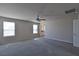 Bright bedroom features neutral carpet and a ceiling fan, with ensuite bathroom entrance at 8324 S Miller Ln, Las Vegas, NV 89113