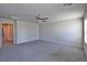 Carpeted bedroom with ceiling fan, neutral paint, and entrances to bathroom and hallway at 8324 S Miller Ln, Las Vegas, NV 89113