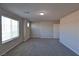 This bonus room features neutral walls, carpeted floors, and large windows for natural light at 8324 S Miller Ln, Las Vegas, NV 89113