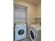 Bright laundry room with modern, white front-load Samsung washer and dryer with overhead shelving at 8324 S Miller Ln, Las Vegas, NV 89113