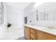 Bright bathroom featuring white walls, tile floors, and a dual sink vanity at 9013 Meisenheimer Ave, Las Vegas, NV 89143