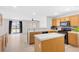 Bright kitchen features wooden cabinetry, a center island, and a view into the living area at 9013 Meisenheimer Ave, Las Vegas, NV 89143