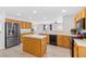 Well-lit kitchen boasts stainless steel refrigerator, kitchen island, and wood cabinetry at 9013 Meisenheimer Ave, Las Vegas, NV 89143