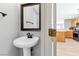 Cozy powder room featuring a pedestal sink, framed mirror, and neutral decor at 9013 Meisenheimer Ave, Las Vegas, NV 89143