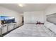 Bright bedroom with plush white bedding, a modern TV, and a well-lit ambiance for ultimate relaxation and entertainment at 9045 Knots Estate St, Las Vegas, NV 89139