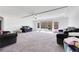 Spacious living room with neutral carpet, recessed lighting, and two dark-colored couches at 9045 Knots Estate St, Las Vegas, NV 89139
