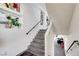 Bright staircase featuring gray tile steps, white walls, and black handrails at 9045 Knots Estate St, Las Vegas, NV 89139