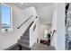 Bright staircase featuring gray tile steps, white walls, and black handrails at 9045 Knots Estate St, Las Vegas, NV 89139