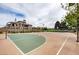 Well-maintained basketball court with a residential home and lush greenery in the background at 985 Via Lombardi Ave, Henderson, NV 89011