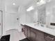 Bathroom featuring double sinks, a large mirror, and a glass-enclosed shower for a spa-like experience at 985 Via Lombardi Ave, Henderson, NV 89011