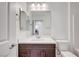 Bright bathroom with a vanity, white countertop, square mirror, and access to laundry area at 985 Via Lombardi Ave, Henderson, NV 89011