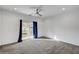 Spacious bedroom with neutral carpet, a ceiling fan, and a sliding glass door to the balcony at 985 Via Lombardi Ave, Henderson, NV 89011