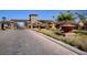 Elegant community entrance featuring Mediterranean architecture, decorative planters, and palm trees at 985 Via Lombardi Ave, Henderson, NV 89011