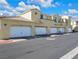 Exterior of townhomes featuring individual garages, tile roofs and a well maintained street at 985 Via Lombardi Ave, Henderson, NV 89011