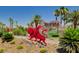 Beautiful desert landscape welcomes you to the Chimera Golf Club, adorned with palm trees and desert foliage at 985 Via Lombardi Ave, Henderson, NV 89011