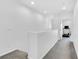 Well-lit upper hallway featuring neutral walls and carpet with a view to a room with exercise equipment at 985 Via Lombardi Ave, Henderson, NV 89011