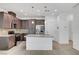 Modern kitchen featuring dark cabinets, granite countertops, and a stainless steel refrigerator at 985 Via Lombardi Ave, Henderson, NV 89011