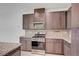 Well-equipped kitchen with modern appliances, granite countertops, and dark wood cabinets at 985 Via Lombardi Ave, Henderson, NV 89011
