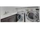 Functional laundry room with sink, cabinets, and stainless steel washer/dryer at 985 Via Lombardi Ave, Henderson, NV 89011