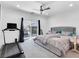 Spacious main bedroom featuring a sliding glass door, ceiling fan, and exercise equipment at 985 Via Lombardi Ave, Henderson, NV 89011
