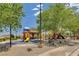 Community playground featuring slides and covered seating areas surrounded by mature landscaping and scenic views at 985 Via Lombardi Ave, Henderson, NV 89011