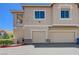 Exterior view of townhomes with garages, showing the architecture and neutral color scheme at 9901 Trailwood Dr # 2109, Las Vegas, NV 89134