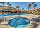 Inviting community hot tub and pool area with clear blue water, lounge seating, and tropical palm trees at 9901 Trailwood Dr # 2109, Las Vegas, NV 89134