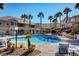 Resort-style pool with palm trees, lounge seating, tropical landscaping, and crystal clear blue water at 9901 Trailwood Dr # 2109, Las Vegas, NV 89134
