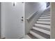 View of the staircase featuring wood-trimmed steps, a white railing, and a door at 9901 Trailwood Dr # 2109, Las Vegas, NV 89134