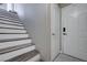 Interior staircase with wood accents leading to a white door, offering a glimpse of the upper level at 9901 Trailwood Dr # 2109, Las Vegas, NV 89134