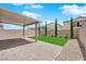 Backyard featuring a covered patio, artificial turf, brick walls, and gravel landscaping for low maintenance at 10029 Cluny Ave, Las Vegas, NV 89178