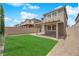 Landscaped backyard featuring lush green turf, gravel accents, brick wall, and a covered patio at 10029 Cluny Ave, Las Vegas, NV 89178