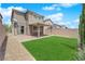 Backyard oasis with green turf, brick-paved patio, gravel accents, and privacy wall, ideal for outdoor living at 10029 Cluny Ave, Las Vegas, NV 89178