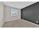 Bedroom with a dark accent wall, plush carpeting, and bright window at 10029 Cluny Ave, Las Vegas, NV 89178