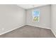 Cozy bedroom featuring a window, neutral walls, and plush carpeting at 10029 Cluny Ave, Las Vegas, NV 89178