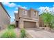 Two-story home featuring neutral stucco, stone accents, a two-car garage, and a paved driveway at 10029 Cluny Ave, Las Vegas, NV 89178