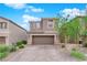 Two-story home featuring neutral stucco, stone accents, a two-car garage, and a paved driveway at 10029 Cluny Ave, Las Vegas, NV 89178