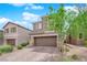 Two-story home featuring neutral stucco, stone accents, a two-car garage, and a paved driveway at 10029 Cluny Ave, Las Vegas, NV 89178