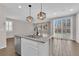 This kitchen has an island with granite countertops, modern lighting fixtures, and stainless steel appliances at 10029 Cluny Ave, Las Vegas, NV 89178