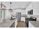 Modern kitchen with white cabinets, granite countertops, stainless steel appliances, and a kitchen island at 10029 Cluny Ave, Las Vegas, NV 89178