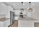 The kitchen includes white cabinets, stainless steel appliances, and an island with granite countertops at 10029 Cluny Ave, Las Vegas, NV 89178
