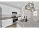 Well-lit kitchen includes granite countertops, stainless steel appliances, and trendy pendant lighting at 10029 Cluny Ave, Las Vegas, NV 89178