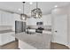 Modern kitchen with white cabinets, granite countertops, stainless steel appliances, and a kitchen island at 10029 Cluny Ave, Las Vegas, NV 89178