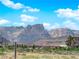 Home features a red tile roof and solar panels, set against a backdrop of desert landscape and majestic mountains at 10029 Cluny Ave, Las Vegas, NV 89178