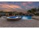 Outdoor pool area with a waterfall, spa, and built in bar with amazing sunset at 10084 Terrastone Dr, Las Vegas, NV 89148