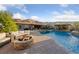 Inviting backyard pool with stone fire pit and stunning mountain views in the background at 10084 Terrastone Dr, Las Vegas, NV 89148