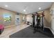 Bright exercise room with equipment, ceiling fan, and access to backyard with scenic views at 10084 Terrastone Dr, Las Vegas, NV 89148