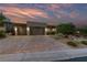 Attractive home with a three-car garage, desert landscaping, and a paved driveway, blending style and functionality at 10084 Terrastone Dr, Las Vegas, NV 89148